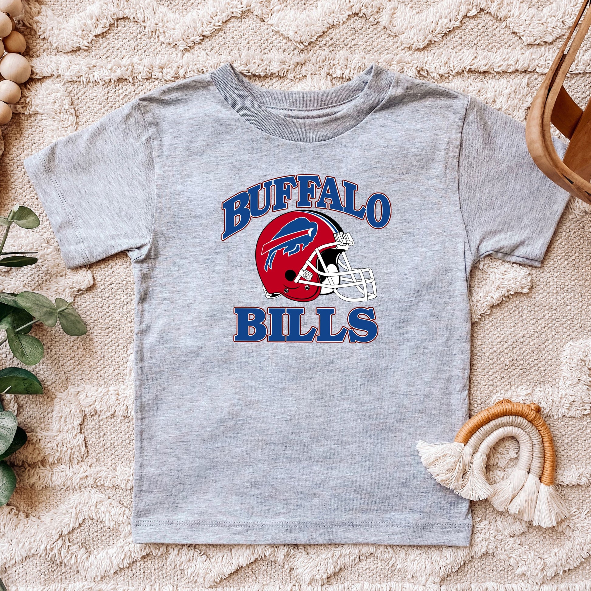 a child's buffalo bills t - shirt sitting on top of a rug