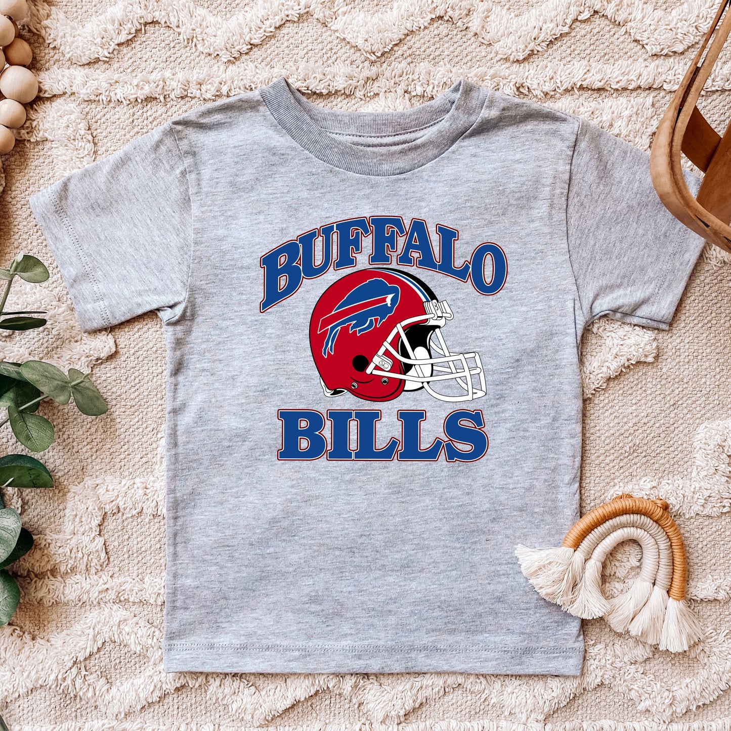 a child's buffalo bills t - shirt sitting on top of a rug