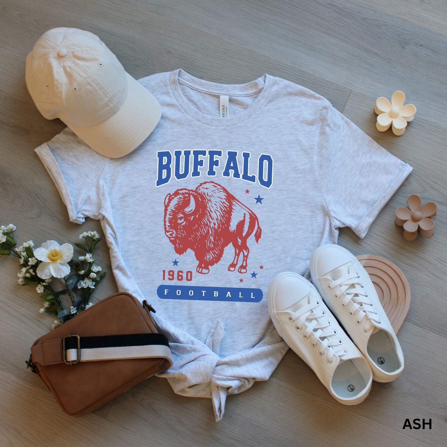 a white shirt with buffalo on it next to a pair of shoes